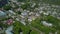 Bird\'s-eye view. Clip. A small village with its own houses and industry, roads and parks and green trees around.