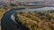 Bird`s eye view of the curving river near forest during autumn time