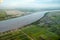 Bird`s-eye view of the Demerara River, rural houses, rectangular green fields taken from an airplane, South America. Rivers