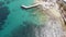 Bird\\\'s eye view of Pier extending over Clear Mediterranean water on the shores of Sliema, in Malta - Fly-over aerial shot