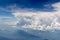 The bird's eye view on the sky with the huge fluffy dramatic clouds above the Alps