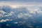 The bird's eye view on the sky with the huge fluffy dramatic clouds above the Alps