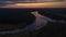 Bird`s eye view of the sunrise above forest and river curves