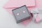 Bird shape with heart earring studs in gray gift box on pink envelope background