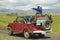 Bird watchers and red jeep in spring grasslands and mountains in Centennial Valley, Lakeview MT