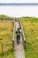 Bird watchers walking on a footbridge by a lake