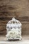 Birdcage with flowers inside on rustic wood