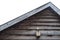 Birdhouse is located under the roof of a wooden house, against the background of a cloudy sky and snowflakes