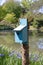 Birdhouse painted blue on a sprouting tree stump, rustic lake and Siberian iris, bluebird house