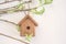 Birdhouse on willow twigs on white background