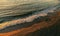 Birds eye aerial view of some seagulls standing on a beach and flying over the sea