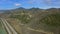 Birds eye panorama shot of the highway with car traffic near the Pacific ocean and plantation field