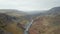 Birds eye stunning and surreal landscape of Haifoss valley in Iceland with river Fossa flowing on riverbed. Aerial view