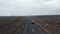 Birds eye view road, first in Iceland, with panorama highlands and driving car speeding up on asphalt. Drone view of