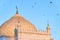 Birds fly around the dome of the white mosque in Bolgar