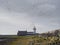 Birds flying over old white lighthouse, Mutton Island, Galway city Ireland. Cloudy sky