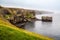Birds market green grassland rock cliffs at Iceland wild ocean coast panorama