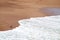 Birds on the Red Beach or Playa Roja crashing by white wave foam, Paracas, Peru