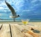 Birds on sea ,seagull and glass of juice  on wooden table top at beach resort   sea landscape ,blue sky,marine water sunny day rel