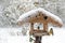 Birdseed house with coal tits in the snow, copy space