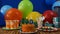 Birthday 90 cake on rustic wooden table with background of colorful balloons, gifts, plastic cups, plastic plate