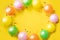 Birthday background. Colorfull balloons and candies on yellow table. Place for your text