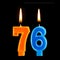 Birthday burning candles in the form of 76 seventy six for cake isolated on black background.