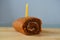 Birthday cake and a candle on top on a wooden board.