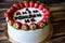 Birthday cake. Cheesecake topped with happy birthday inscription and strawberries. Artwork.