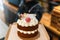 Birthday cake held by an unrecognizable baker in a bakery.