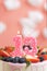 Birthday cake number 13. Beautiful pink candle in cake on pink background with white clouds. Close-up and vertical