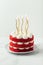 Birthday cake with red velvet sponge layers and white cream cheese filling
