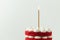 Birthday cake with red velvet sponge layers and white cream cheese filling decorated with lit golden candle