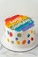 Birthday cake with white cream cheese frosting decorated with rainbow colored butter cream smears and happy birthday text on top.