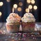Birthday candles glow adorning two cupcakes. Delicious birthday cupcake on table.