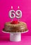 Birthday card with candle number 69 - Chocolate cake on pink background