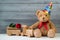 Birthday concept, teddy bear in party cap and wooden toy train