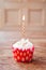 Birthday cupcake blurry background with lit candle