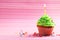 Birthday cupcake with butter cream and candle on colorful background