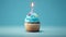 Birthday cupcake with a candle  on light blue background with balloons. Generative Ai