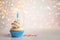 Birthday cupcake with candle on light table. Bokeh effect