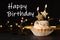 Birthday cupcake with candles and text Happy Birthday against black background