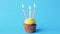 Birthday cupcake with four burning candles
