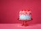 Birthday Drip Cake on a red stand and colorful sprinkles on a vibrant pink background