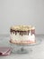 Birthday Drip Layered Cake with chocolate ganache and sprinkles on a white background with party decor. Horizontal. Copy space. Ce