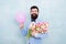 Birthday gifts for her. Happy hipster hold flowers and birthday balloon. Tulip bouquet for birthday greetings