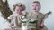 Birthday, little sisters touches cake with hands sits in dresses on photo shoot in studio