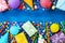 Birthday party banner or background with colorful carnival caps, balloons, gift or present boxes and confetti. Top view