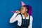 Birthday party, new year carnival. Young smiling African woman on blue background celebrating brightful event, wears