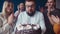 Birthday Portrait adult man with beard and glasses surrounded by his wife and children blows out candles on cake and